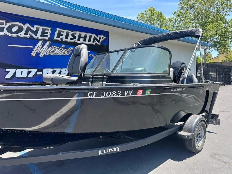 Slide: The Image of 2022 Lund 1650 Rebel XL Sport boat parked outside a marine shop. - 7
