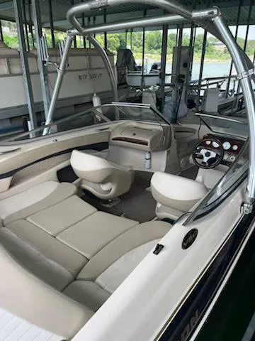 Slide: The Image of 2004 Glastron GS 205 boat interior with seating and steering wheel in a marina. - 7
