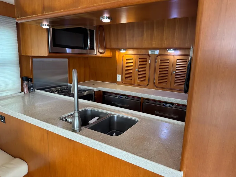 Slide: The Image of Galley kitchen in 2003 Nordhavn N46 yacht with modern appliances and wooden cabinetry. - 16