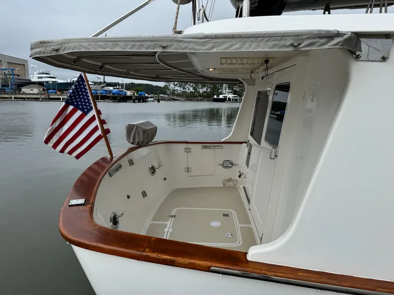 Slide: The Image of 2003 Nordhavn N46 yacht stern with American flag, docked in a marina. - 3