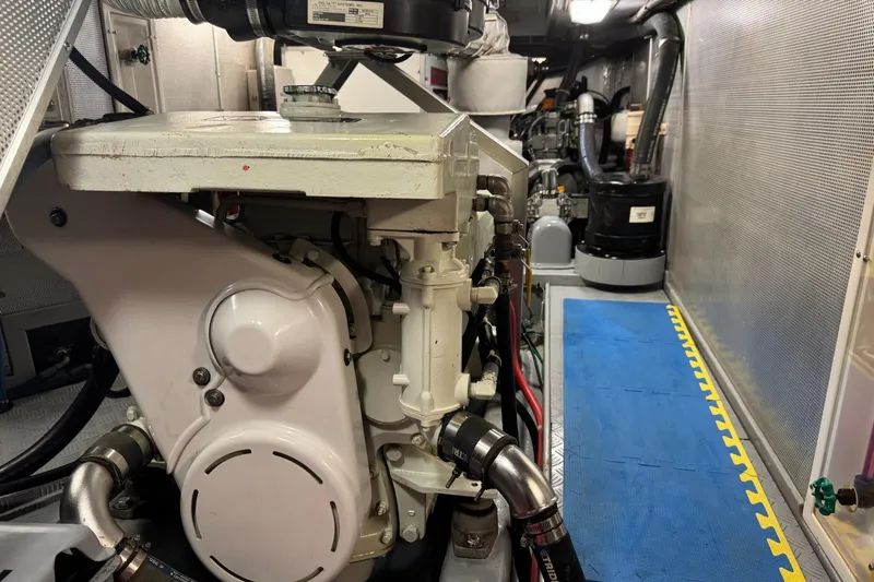 Slide: The Image of Engine room of a 2003 Nordhavn N46 yacht, featuring mechanical components and blue flooring. - 33