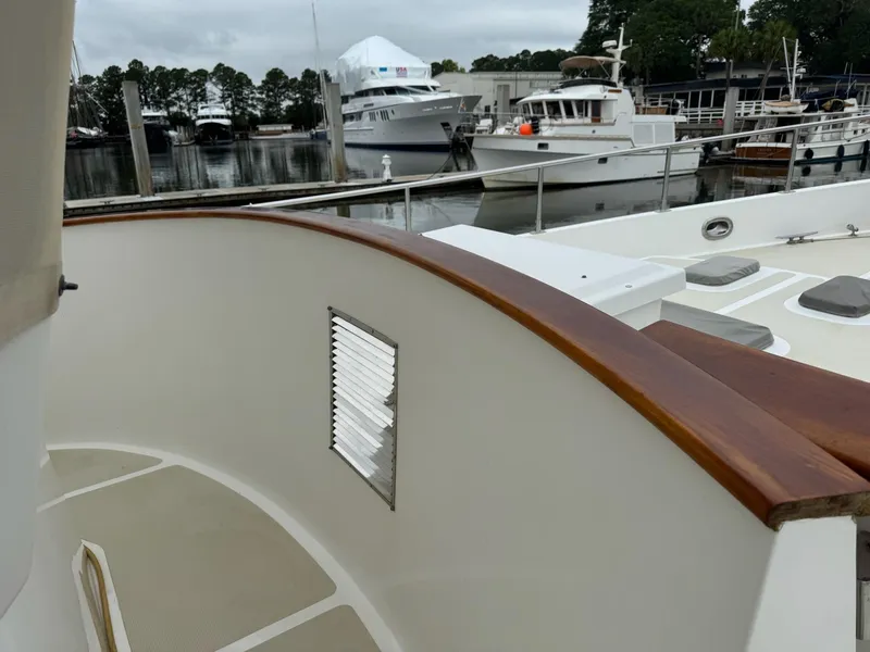 Slide: The Image of 2003 Nordhavn N46 yacht deck with wooden railing, docked at marina. - 7