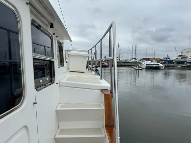 Slide: The Image of 2003 Nordhavn N46 yacht docked at marina, showcasing side deck and railing. - 8