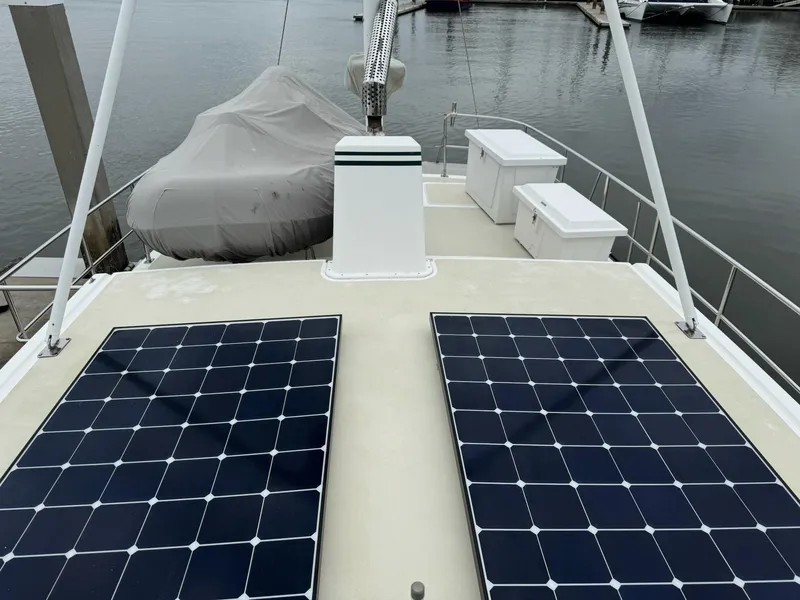 Slide: The Image of 2003 Nordhavn N46 yacht with solar panels on deck, docked at marina. - 9