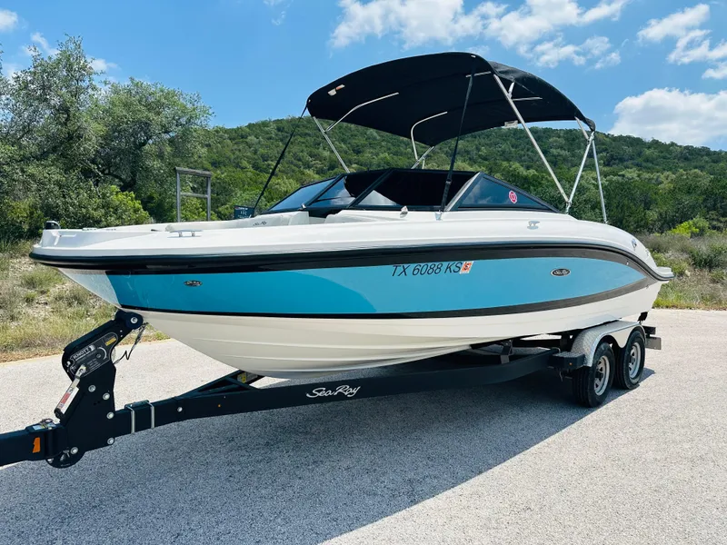 Slide: The Image of 2022 Sea Ray SPX 210 boat on trailer, parked outdoors under a clear sky. - 15