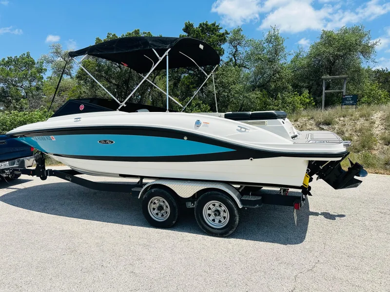Slide: The Image of 2022 Sea Ray SPX 210 boat on trailer, blue and white design, parked outdoors. - 17
