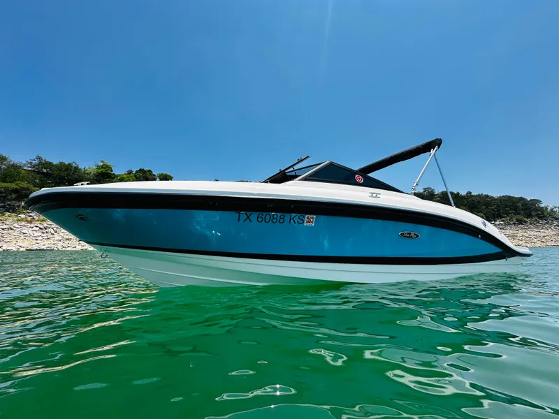 Slide: The Image of 2022 Sea Ray SPX 210 boat on clear water under blue sky. - 2