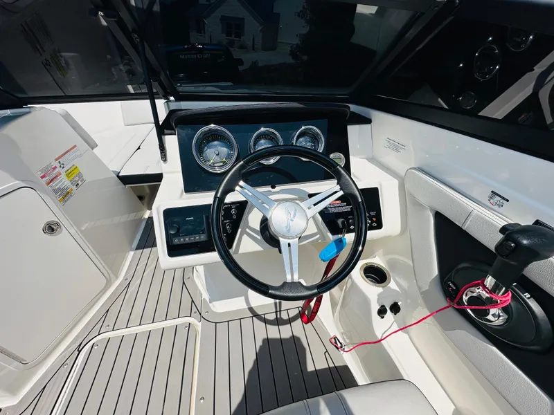 Slide: The Image of 2022 Sea Ray SPX 210 boat cockpit with steering wheel and control panel. - 25