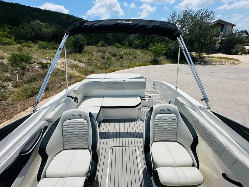 Slide: The Image of 2022 Sea Ray SPX 210 boat interior with seating and canopy, set against a scenic backdrop. - 28
