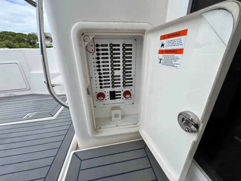 Slide: The Image of Electrical panel on 2005 Riviera 33 Flybridge boat, open with visible circuit breakers. - 11