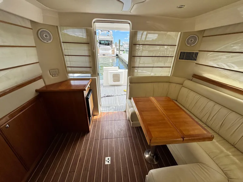 Slide: The Image of Interior of 2005 Riviera 33 Flybridge yacht with wooden flooring and beige seating. - 14