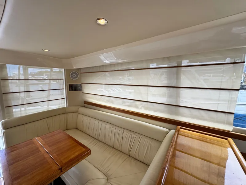 Slide: The Image of Interior of 2005 Riviera 33 Flybridge yacht with beige seating and wooden table. - 16