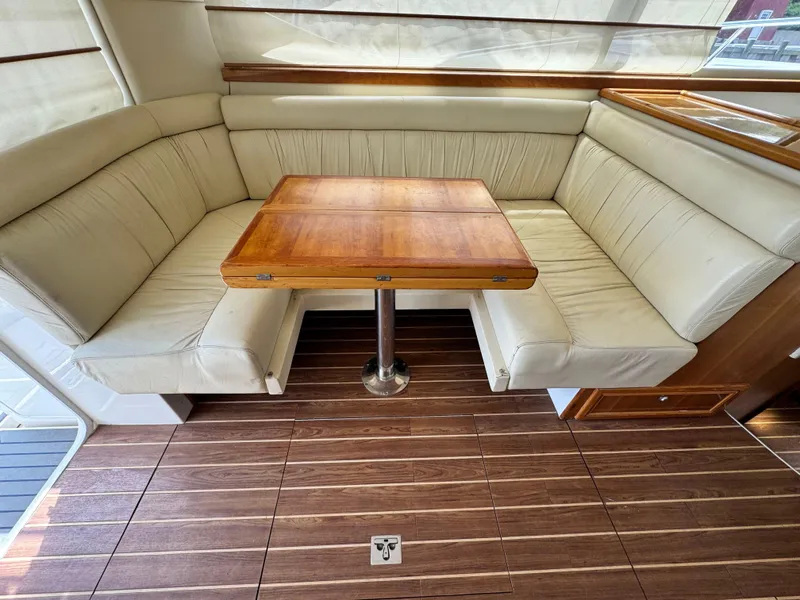 Slide: The Image of Interior of 2005 Riviera 33 Flybridge with wooden table and cream leather seating. - 18