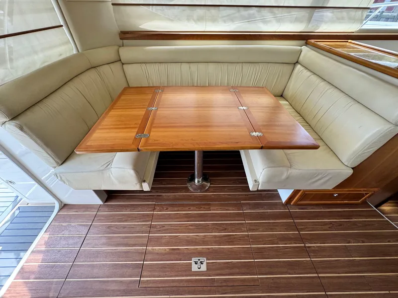 Slide: The Image of 2005 Riviera 33 Flybridge interior with wooden table and leather seating. - 19