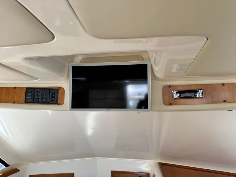 Slide: The Image of 2005 Riviera 33 Flybridge interior with mounted TV and control panel. - 23
