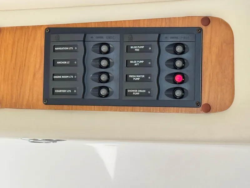 Slide: The Image of Control panel on a 2005 Riviera 33 Flybridge boat with labeled switches. - 24
