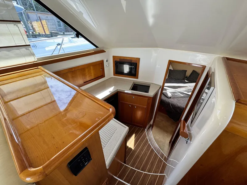 Slide: The Image of Interior of 2005 Riviera 33 Flybridge yacht with wood finishes and cozy cabin. - 26
