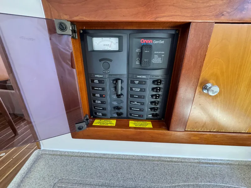 Slide: The Image of Electrical panel on a 2005 Riviera 33 Flybridge boat, featuring Onan GenSet controls. - 28