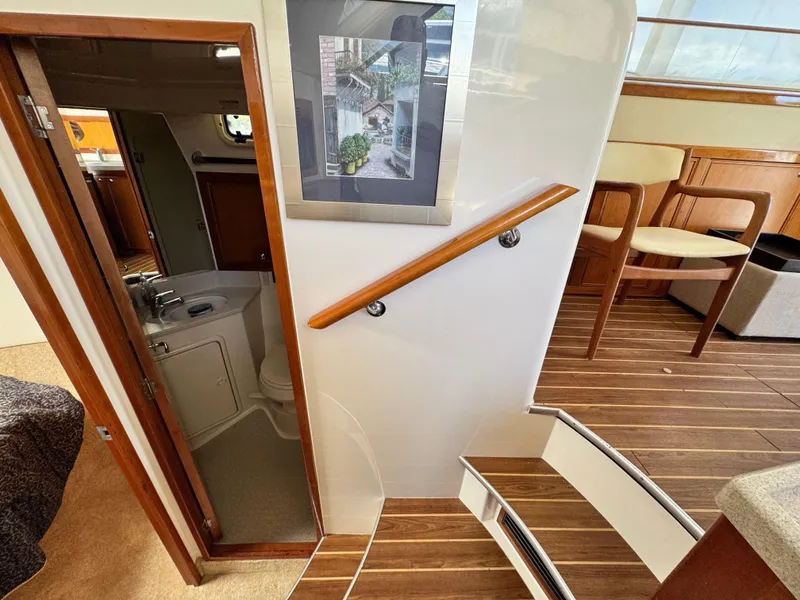 Slide: The Image of Interior of 2005 Riviera 33 Flybridge yacht with wooden stairs and bathroom view. - 32