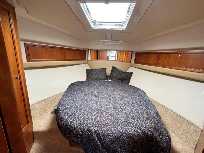 Slide: The Image of Cozy cabin interior of 2005 Riviera 33 Flybridge with bed and wooden storage cabinets. - 35