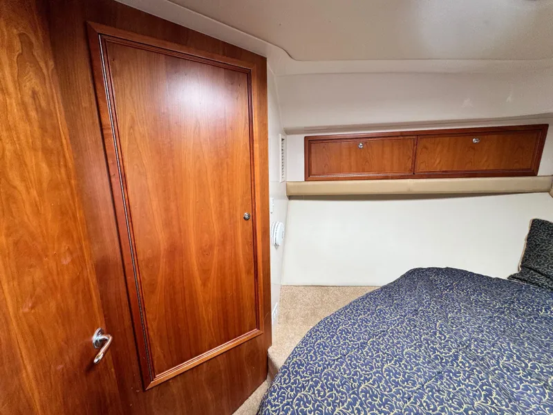 Slide: The Image of 2005 Riviera 33 Flybridge cabin with wooden cabinetry and cozy bedding. - 36