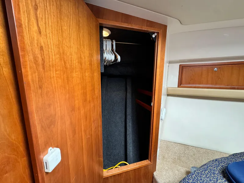 Slide: The Image of Wooden closet interior on 2005 Riviera 33 Flybridge yacht, featuring hangers and storage space. - 37