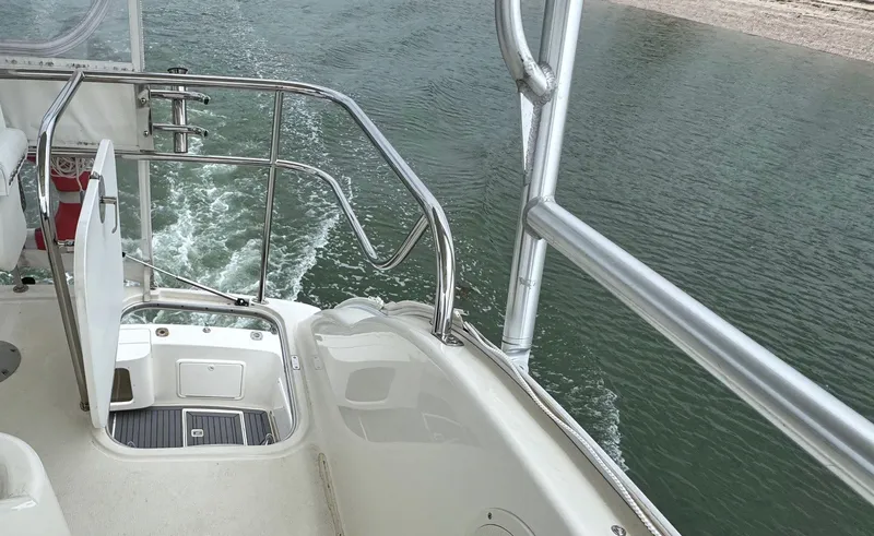Slide: The Image of 2005 Riviera 33 Flybridge boat deck with railing, cruising on water. - 39