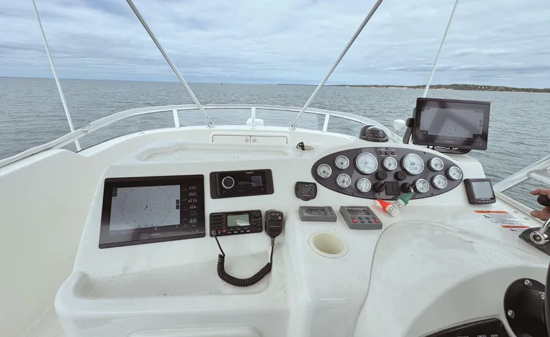 Slide: The Image of Flybridge helm of 2005 Riviera 33, featuring navigation instruments and ocean view. - 41