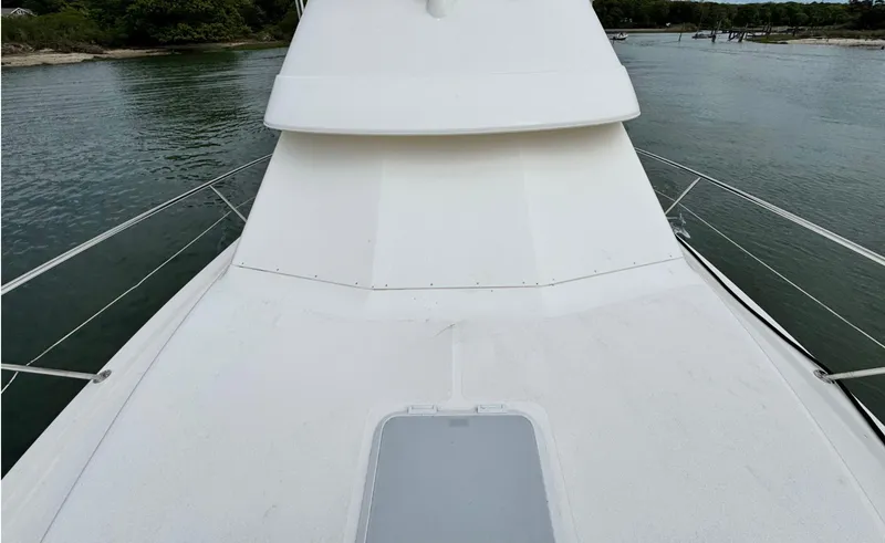 Slide: The Image of 2005 Riviera 33 Flybridge yacht deck, sleek design, cruising on calm waters. - 46