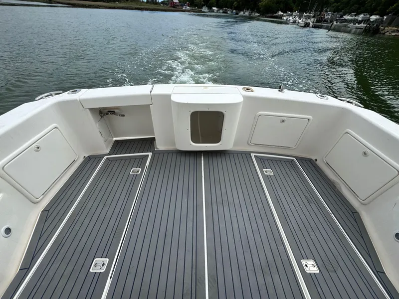 Slide: The Image of 2005 Riviera 33 Flybridge boat deck with sleek flooring, cruising on calm waters. - 7