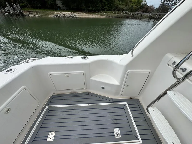 Slide: The Image of 2005 Riviera 33 Flybridge boat deck with storage compartments and water view. - 8