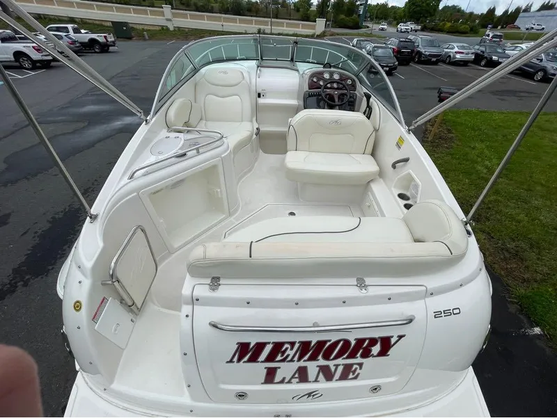 Slide: The Image of 2006 Monterey 250 CR boat with white interior, labeled "Memory Lane," parked in a lot. - 13