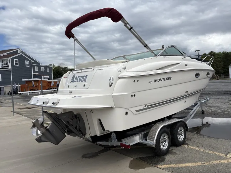 Slide: The Image of 2006 Monterey 250 CR boat on trailer, parked outdoors under cloudy sky. - 27