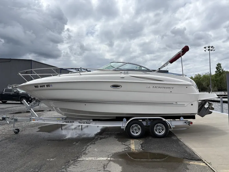 Slide: The Image of 2006 Monterey 250 CR boat on trailer under cloudy sky at marina. - 30