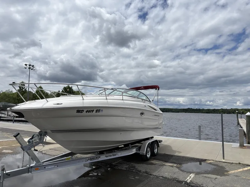 Slide: The Image of 2006 Monterey 250 CR boat on trailer by a lake under cloudy sky. - 31