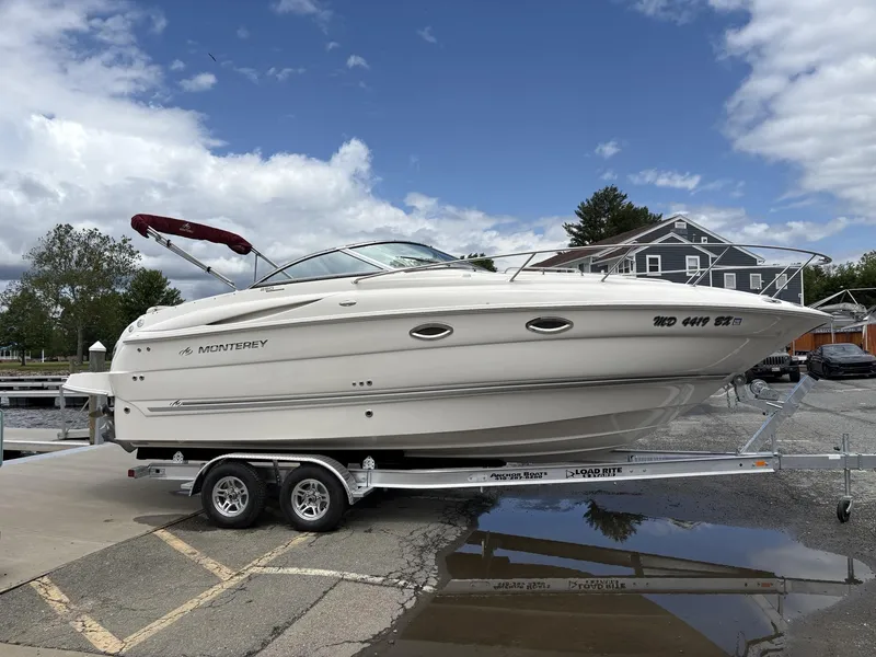 Slide: The Image of 2006 Monterey 250 CR boat on trailer at marina, under cloudy sky. - 32