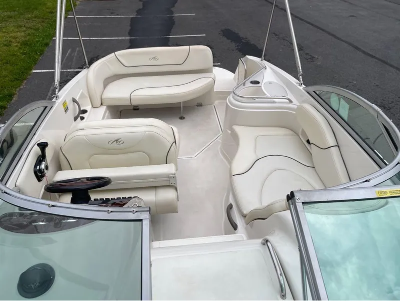 Slide: The Image of Interior of a 2006 Monterey 250 CR boat with white seating and steering wheel. - 34