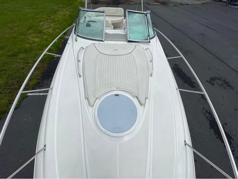 Slide: The Image of 2006 Monterey 250 CR boat deck, white exterior, open windshield, parked on pavement. - 36