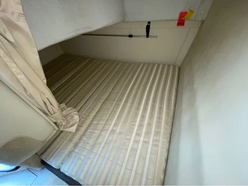 Slide: The Image of Interior cabin of a 2006 Monterey 250 CR boat with beige bedding. - 37