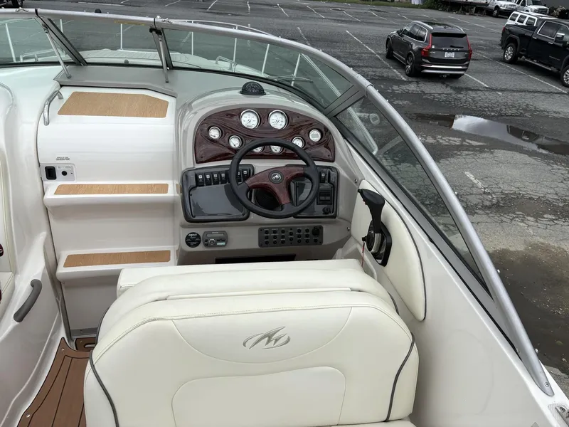 Slide: The Image of 2006 Monterey 250 CR boat cockpit with steering wheel and dashboard controls. - 46