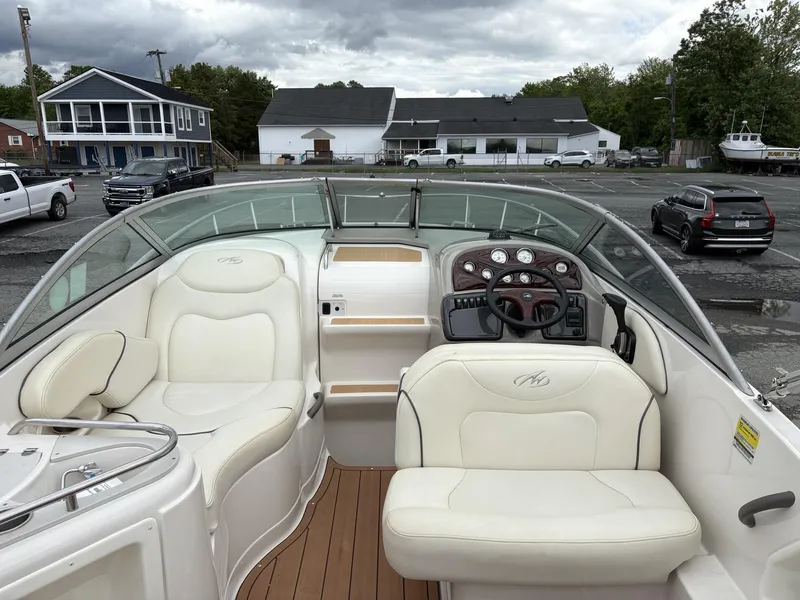 Slide: The Image of Interior of a 2006 Monterey 250 CR boat with white seating and dashboard. - 48