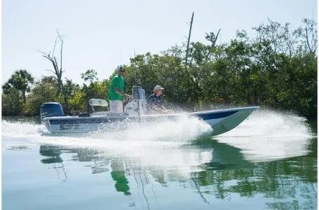 Slide: The Image of 2019 Carolina Skiff 18 JVX CC boat cruising on calm water near trees. - 15