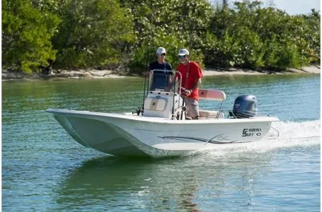 Slide: The Image of 2019 Carolina Skiff 18 JVX CC boat cruising on a calm waterway with two passengers. - 16