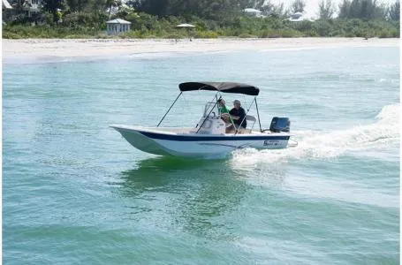 Slide: The Image of 2019 Carolina Skiff 18 JVX CC cruising near a sandy beach. - 2