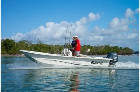Slide: The Image of 2019 Carolina Skiff 18 JVX CC boat cruising on calm water under a clear blue sky. - 6