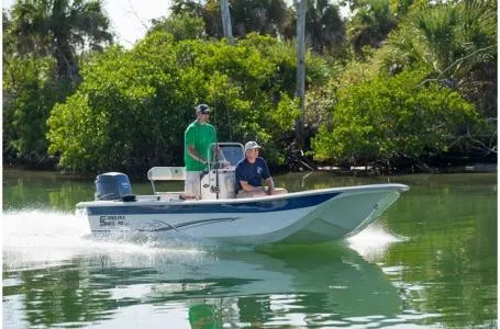 Slide: The Image of 2019 Carolina Skiff 18 JVX CC boat cruising on a calm, green waterway. - 8