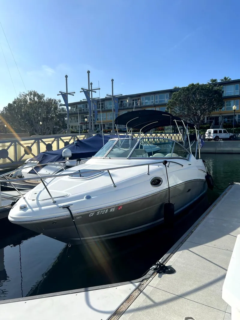 The Image of 2005 Sea Ray Sundancer docked at a marina under clear blue skies. - 1