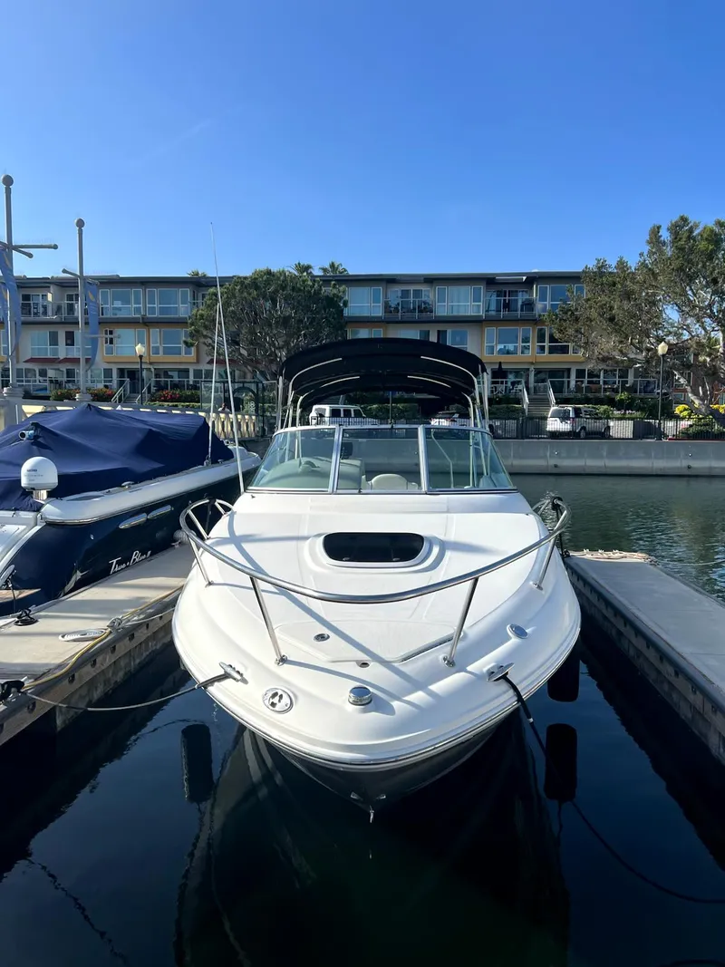 Slide: The Image of 2005 Sea Ray Sundancer boat docked in marina, clear sky, waterfront buildings in background. - 3