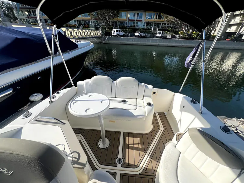 Slide: The Image of 2005 Sea Ray Sundancer boat interior with seating and table, docked in a marina. - 4