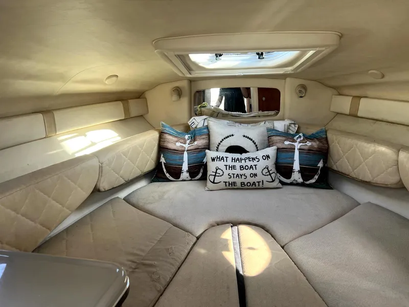 Slide: The Image of 2005 Sea Ray Sundancer cabin with cozy bedding and nautical-themed pillows. - 6